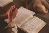 leyendo-la-biblia-manos-orando